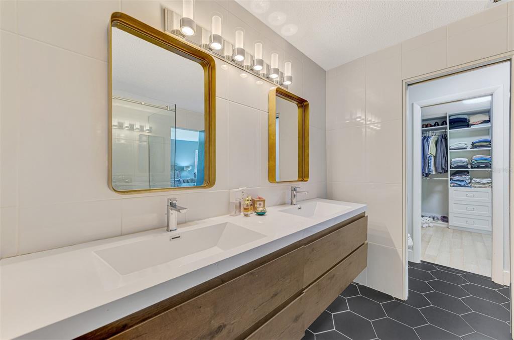 5303 Hidden Harbor Road Sarasota, FL 34242 - Photo 43 of 72 a bathroom with a double vanity sink a mirror and a shower