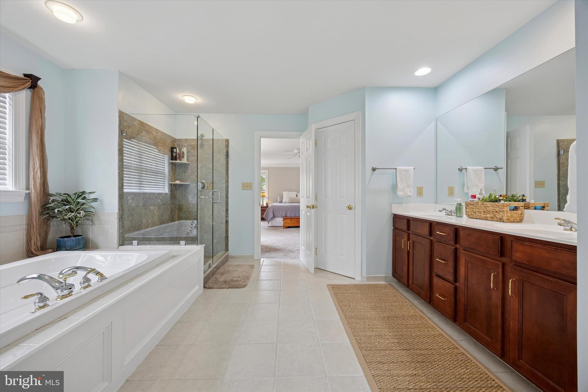 321 Lenni Road Lenni, PA 19052 - Photo 16 of 35 a spacious bathroom with a double vanity sink a large mirror and a bathtub