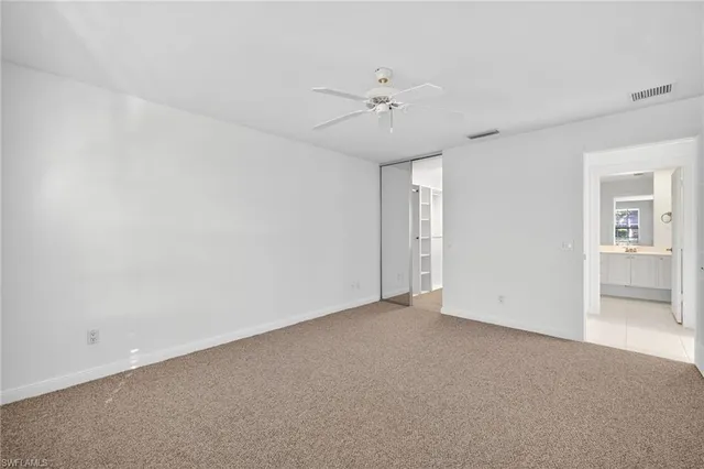an empty room with a ceiling fan and a fan