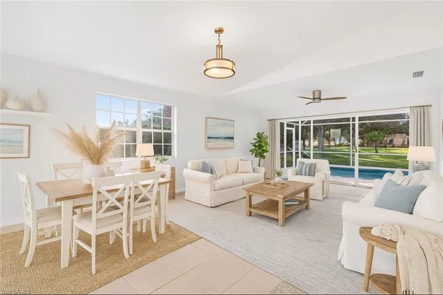 a living room with furniture a chandelier and a window