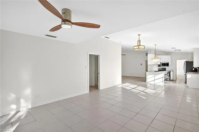 a view of an empty room and kitchen view