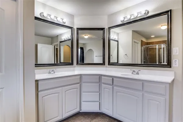 a bathroom with a double vanity sink and a mirror