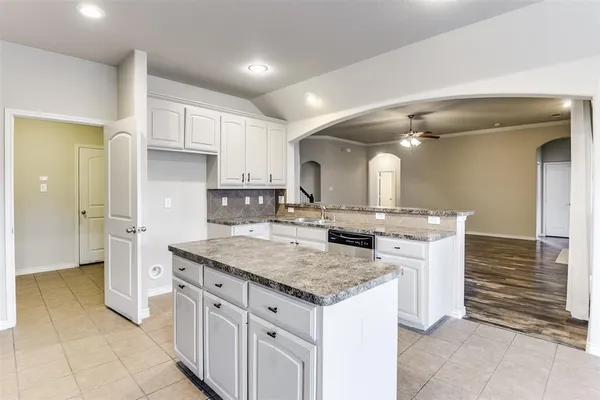 a kitchen with a sink refrigerator and cabinets