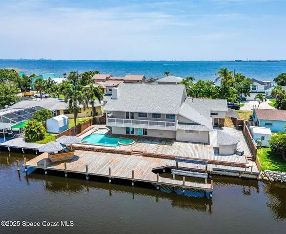 an aerial view of a house with a garden and lake view