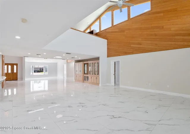 a view of an empty room with closet and a window