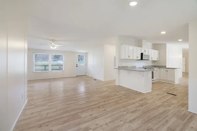 a view of kitchen with granite countertop cabinets and window