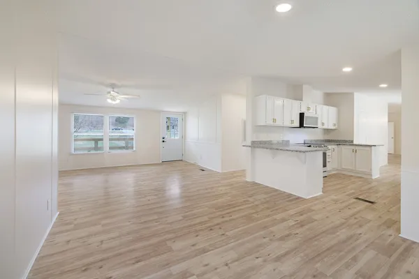 a kitchen with granite countertop white cabinets and white appliances