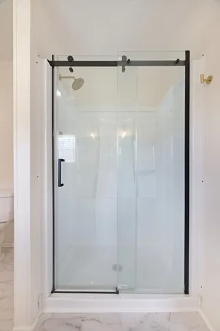 a bathroom with a glass shower door