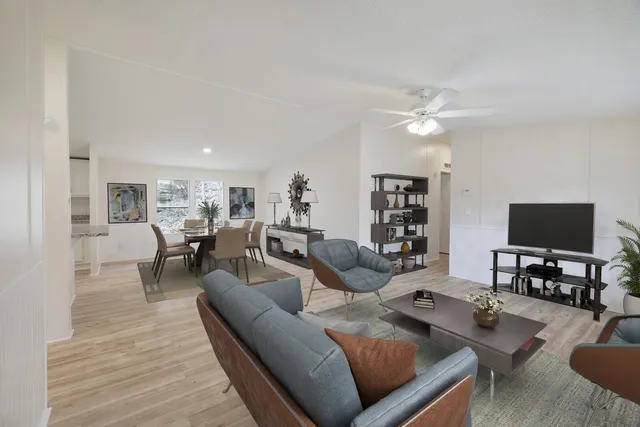a living room with furniture and a flat screen tv with wooden floor