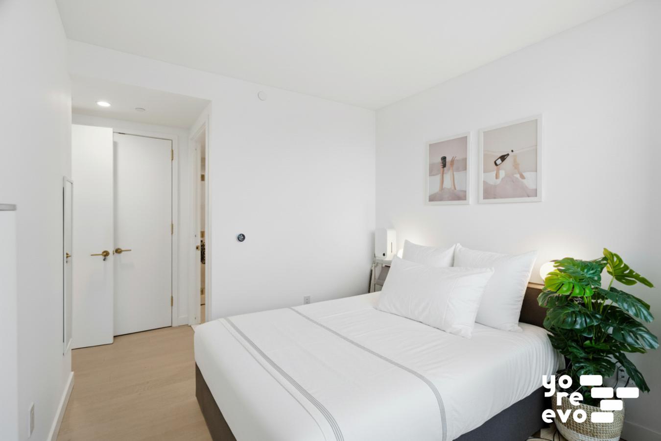 3 Court Square, Unit 4308 Queens, NY 11101 - Photo 4 of 13 a bedroom with a bed and a potted plant