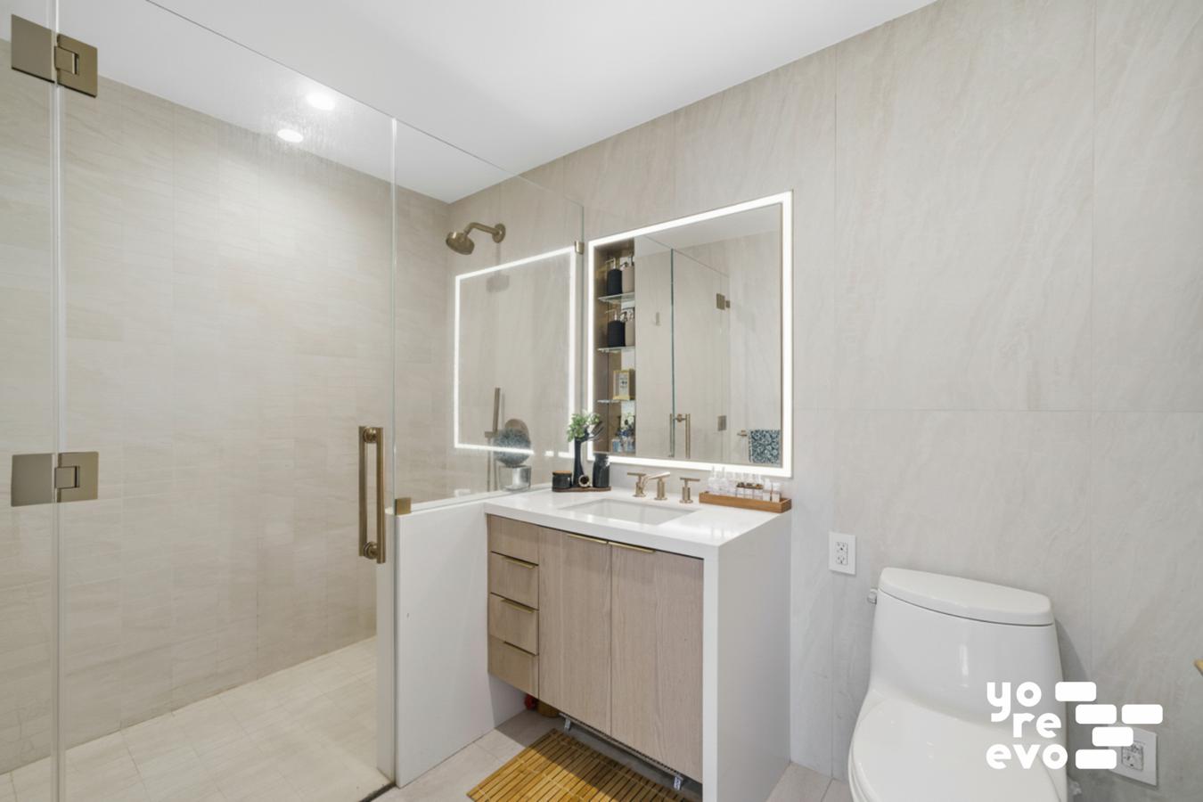 3 Court Square, Unit 4308 Queens, NY 11101 - Photo 5 of 13 a bathroom with a double vanity sink toilet and shower