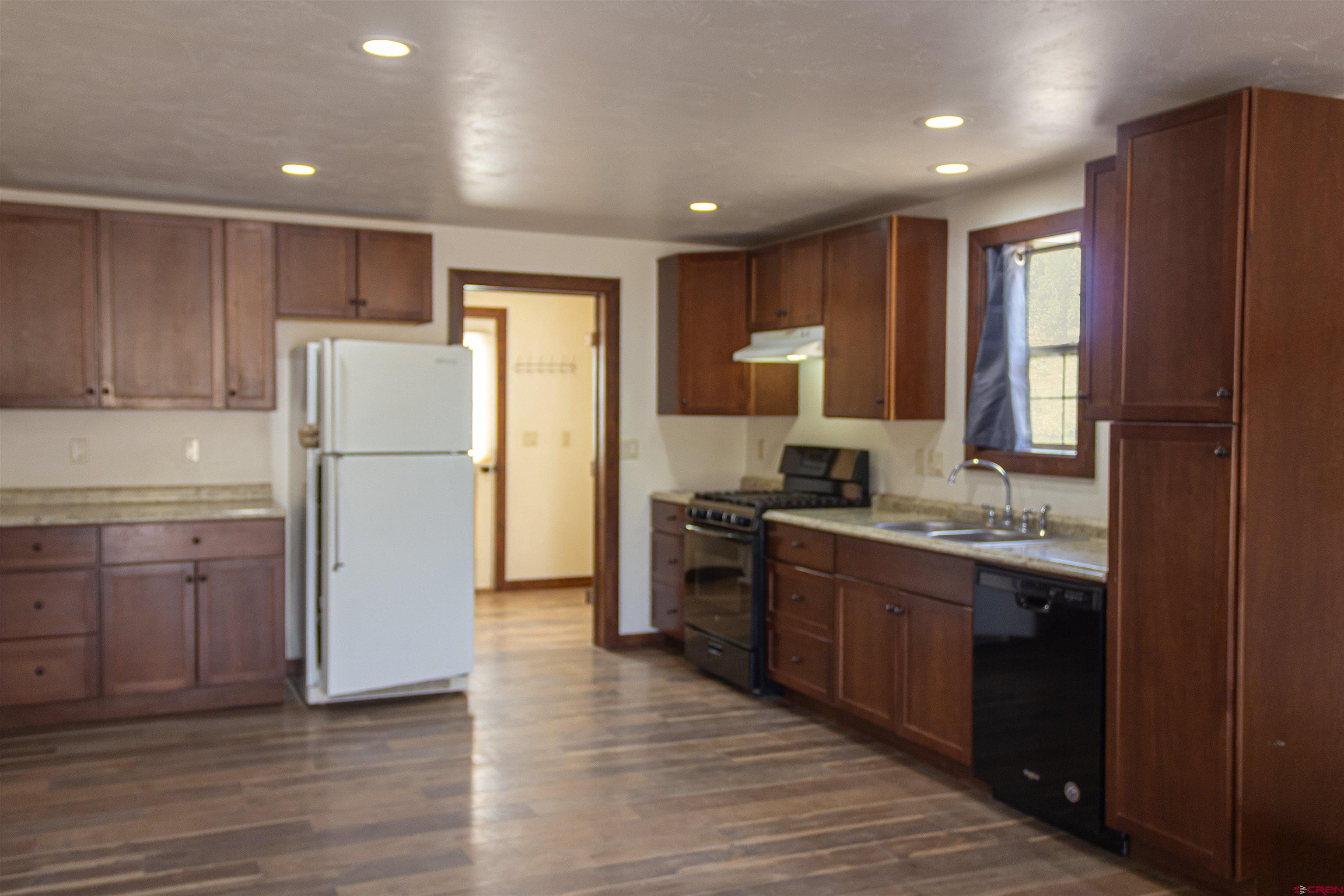 320 County Road 329 Ignacio, CO 81137 - Photo 8 of 45 a kitchen with a refrigerator sink and wooden cabinets