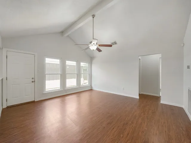 a view of a livingroom with wooden floor and a ceiling fan