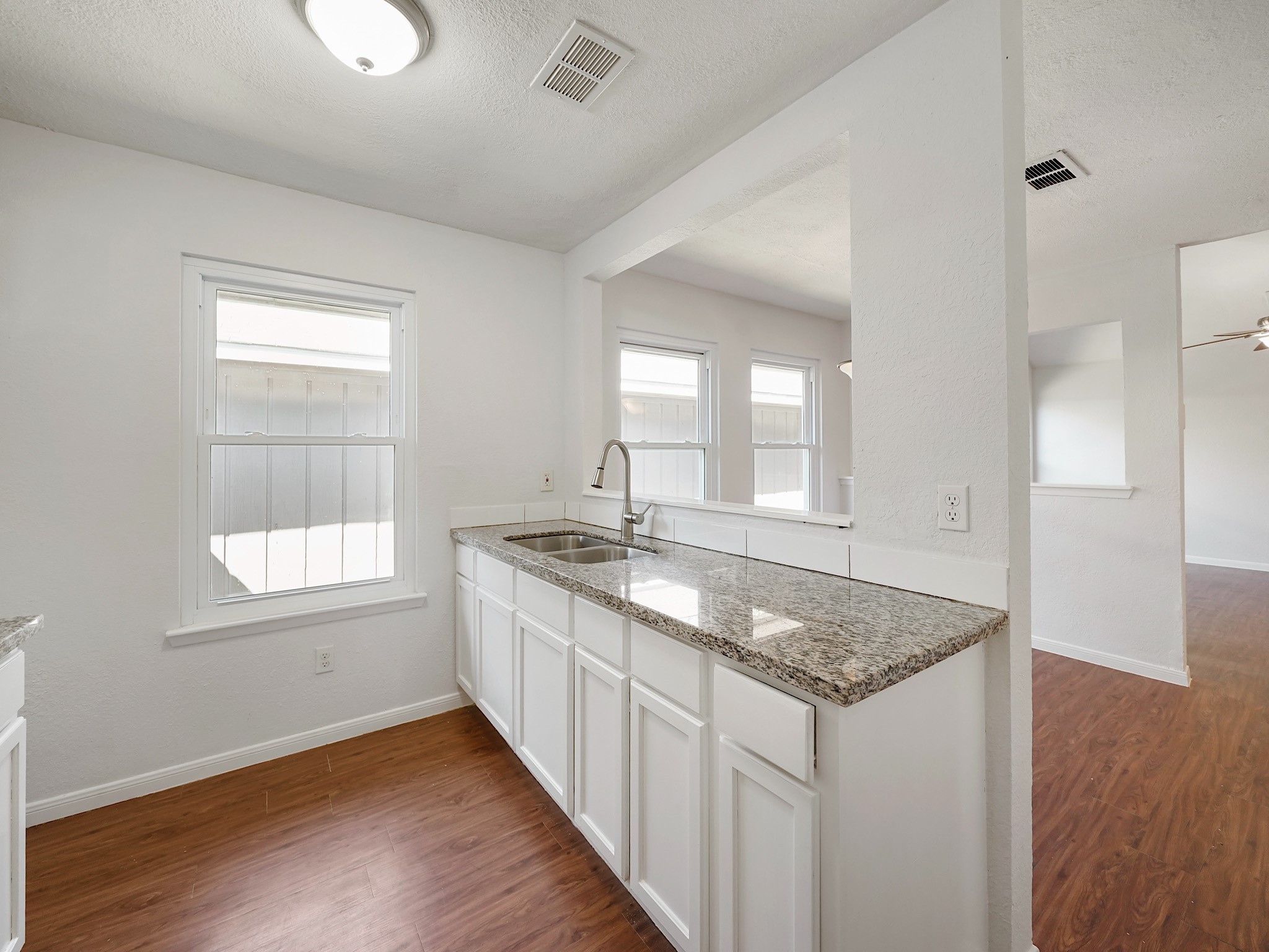 23338 Prairie Bird Drive Spring, TX 77373 - Photo 7 of 18 a kitchen with granite countertop a sink and dishwasher with wooden floor