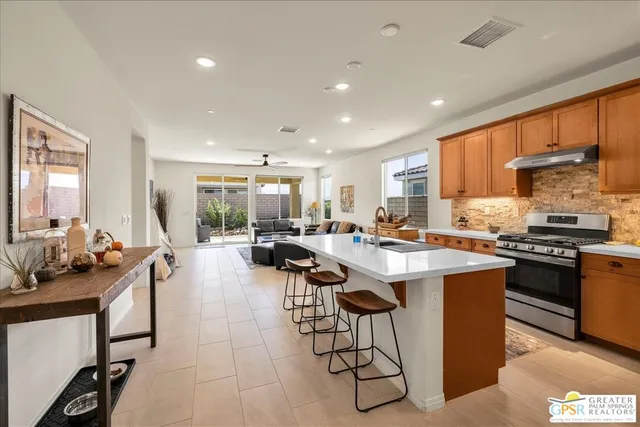 a living room with furniture kitchen view and a window