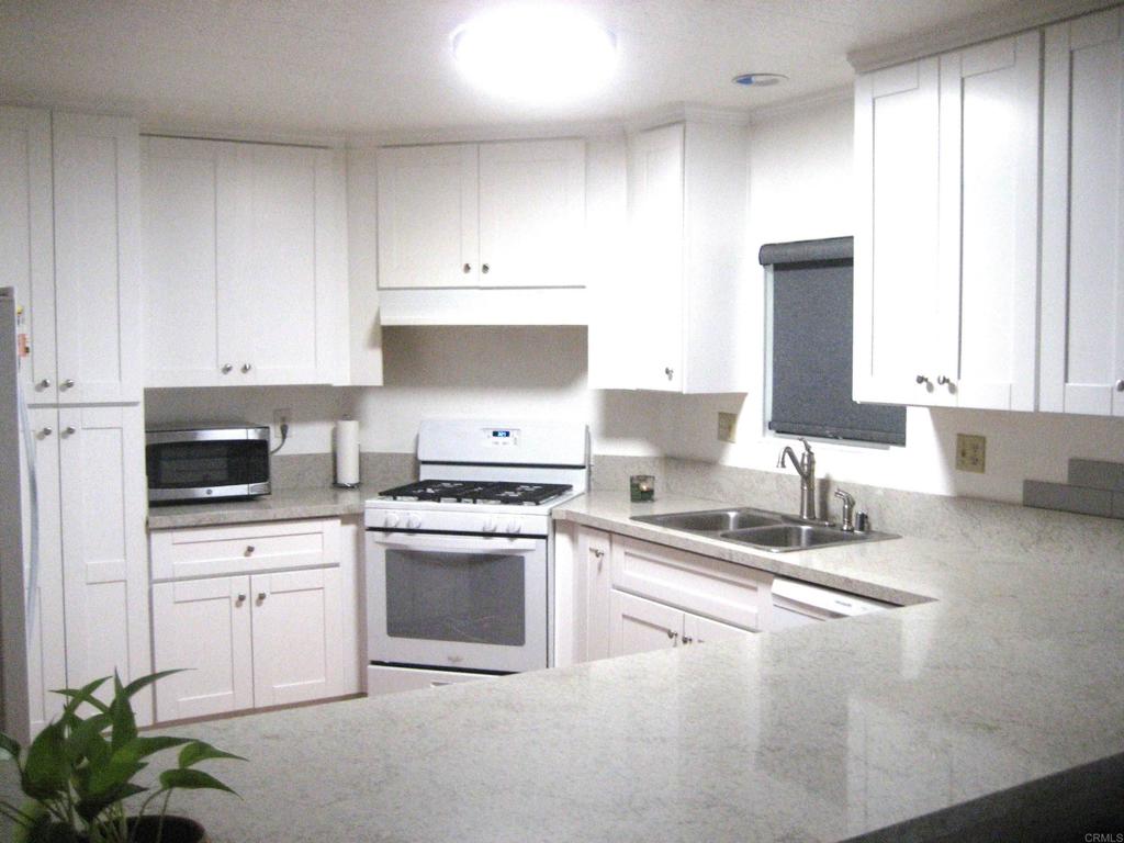 1175 La Moree Road, Unit 33 San Marcos, CA 92078 - Photo 7 of 18 a kitchen with granite countertop a sink stove and cabinets
