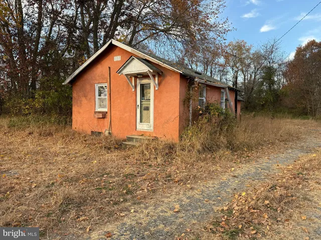 a backyard of a house with lots of plants and trees