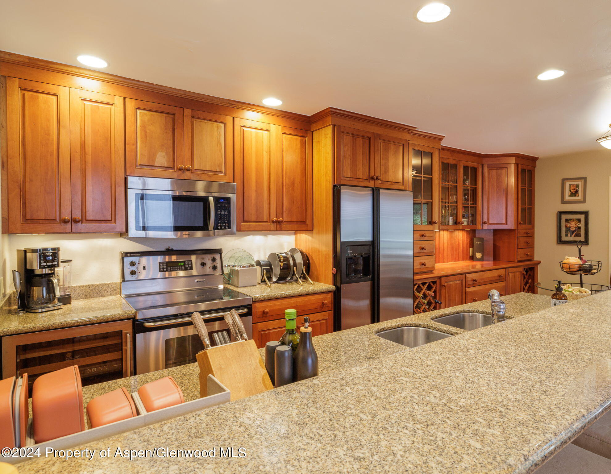 383 Meadow Ranch Road, Unit F4C Snowmass Village, CO 81615 - Photo 8 of 16 a kitchen with stainless steel appliances wooden cabinets a stove top oven a sink and dishwasher