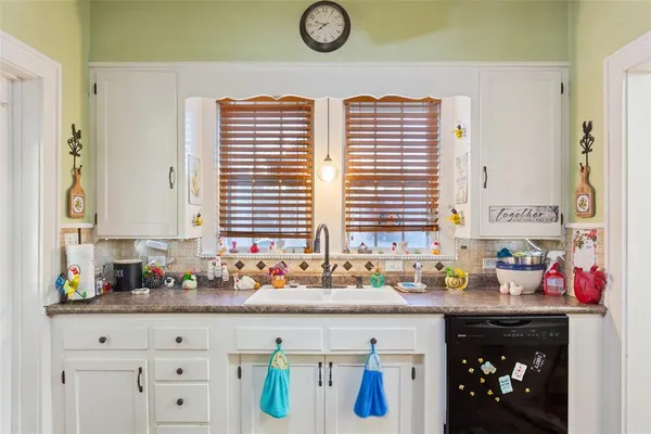 a kitchen with stainless steel appliances granite countertop a sink window and cabinets