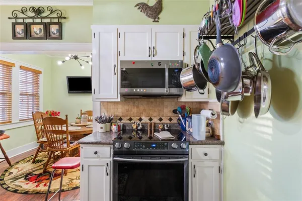 a kitchen with a stove a microwave and dining table