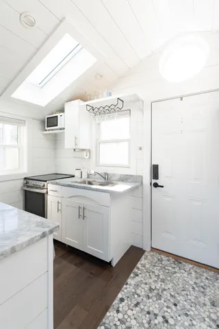 a kitchen with granite countertop white cabinets and white appliances