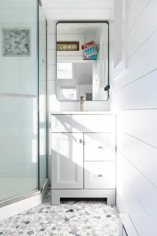 a bathroom with a shower sink and mirror