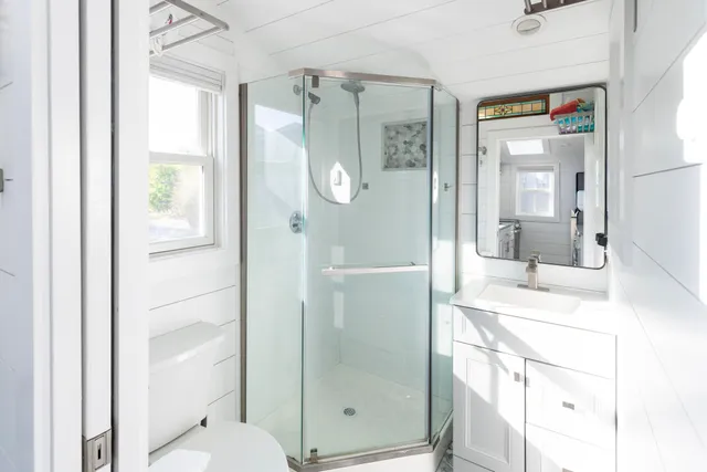 a bathroom with a granite countertop sink toilet and shower