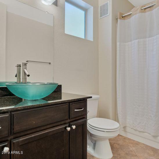 3848 North 3rd Avenue, Unit 1086 Phoenix, AZ 85013 - Photo 14 of 35 a bathroom with a granite countertop toilet sink and mirror