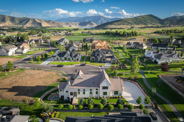 558 West Rheinfalls Circle Midway, UT 84049 - Photo 58 of 61 Elegant residential estate set on expansive grounds featuring a distinctive peaked-roof architectural design with light-colored exterior, mature landscaping with manicured lawn and established trees, curved driveway with paved entry, and mountain vistas a