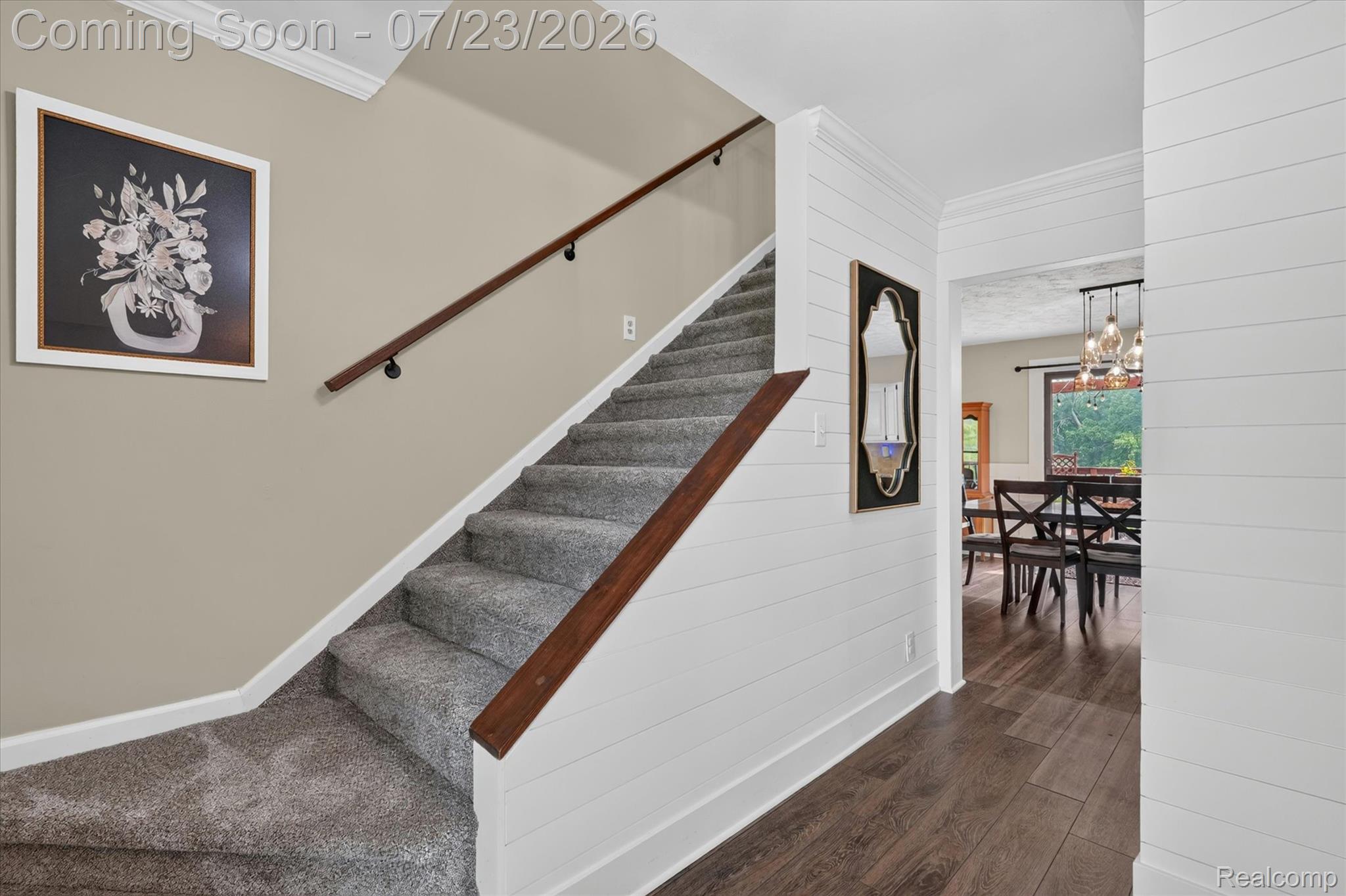 2795 Bird Road Ortonville, MI 48462 - Photo 22 of 62 Carpeted staircase with a wood handrail, contrasting with a shiplap wall and wood-finish flooring