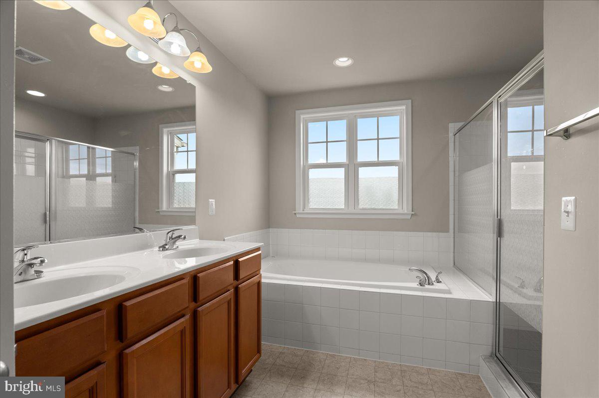 101 Jitterbug Way Stephenson, VA 22656 - Photo 21 of 39 a bathroom with a tub double sink window and mirror