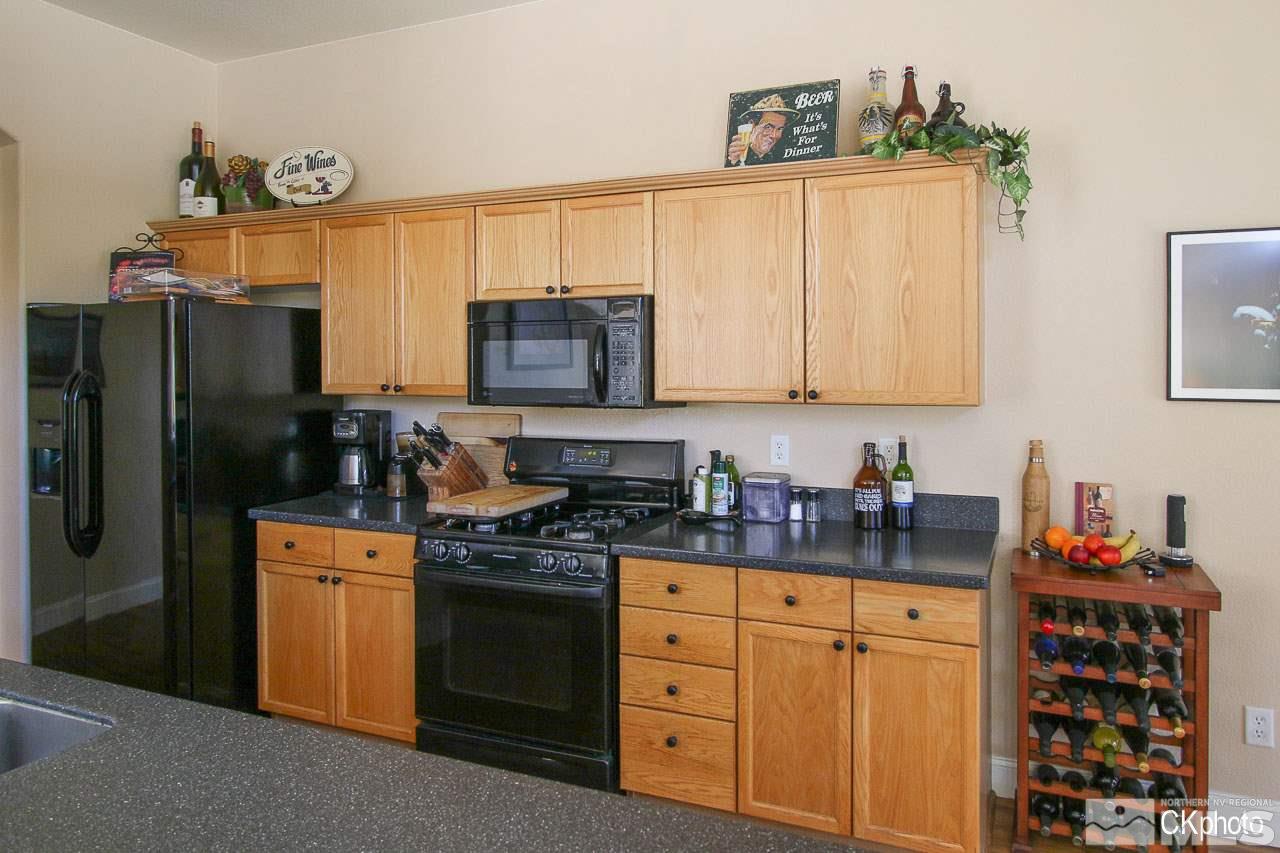 9760 Frankwood Drive Reno, NV 89521 - Photo 7 of 24 a kitchen with stainless steel appliances a stove microwave and refrigerator