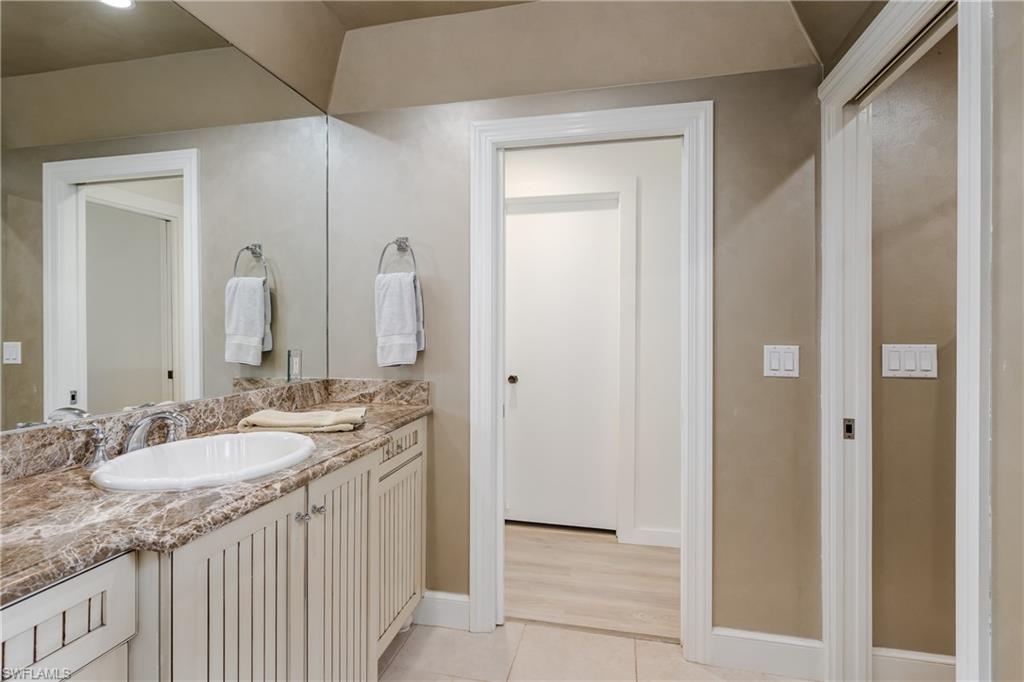 3301 31st Avenue Southwest Naples, FL 34117 - Photo 9 of 22 a bathroom with a granite countertop sink and a mirror
