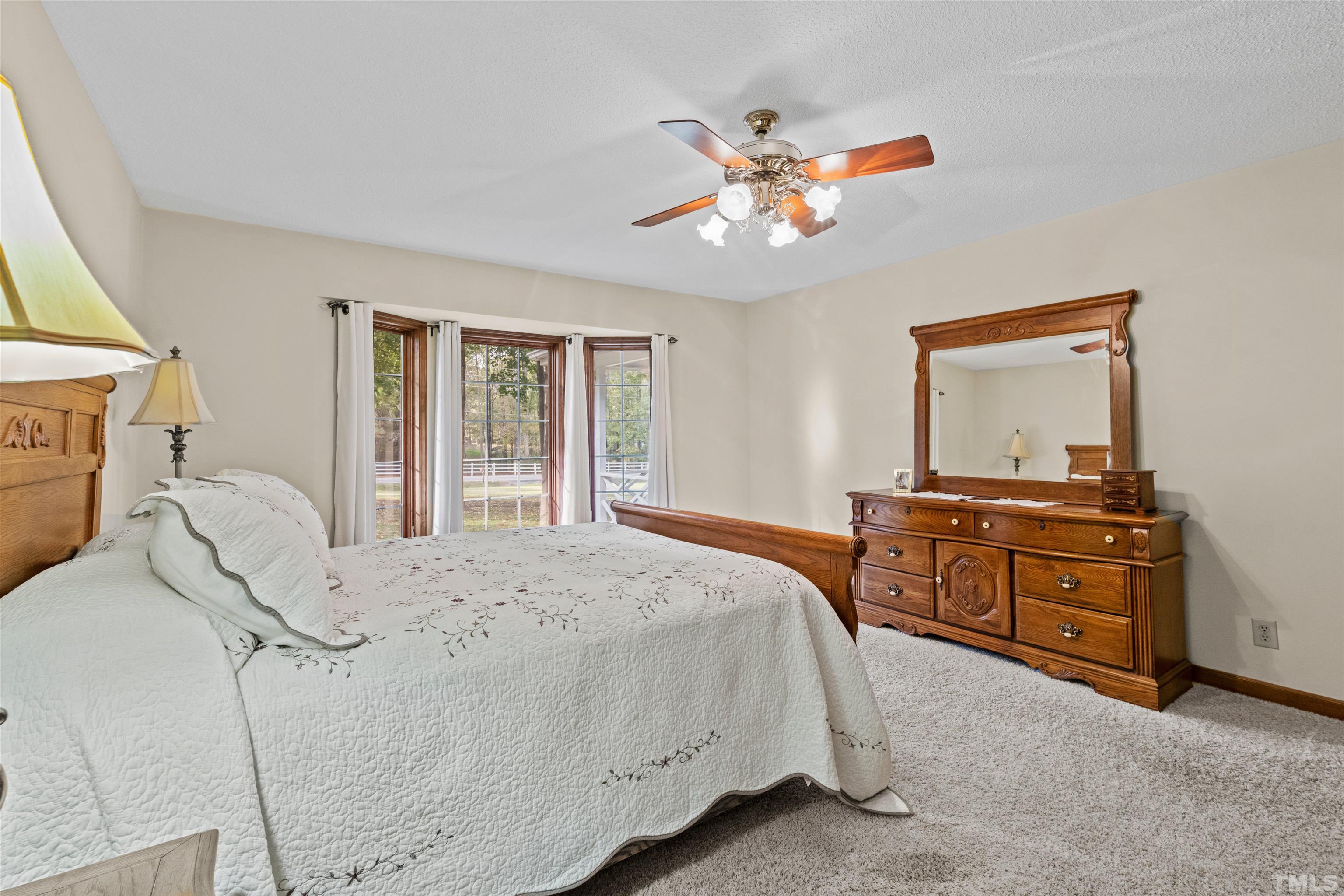 8417 Crowder Road Raleigh, NC 27603 - Photo 17 of 30 a bedroom with a large bed and a chandelier
