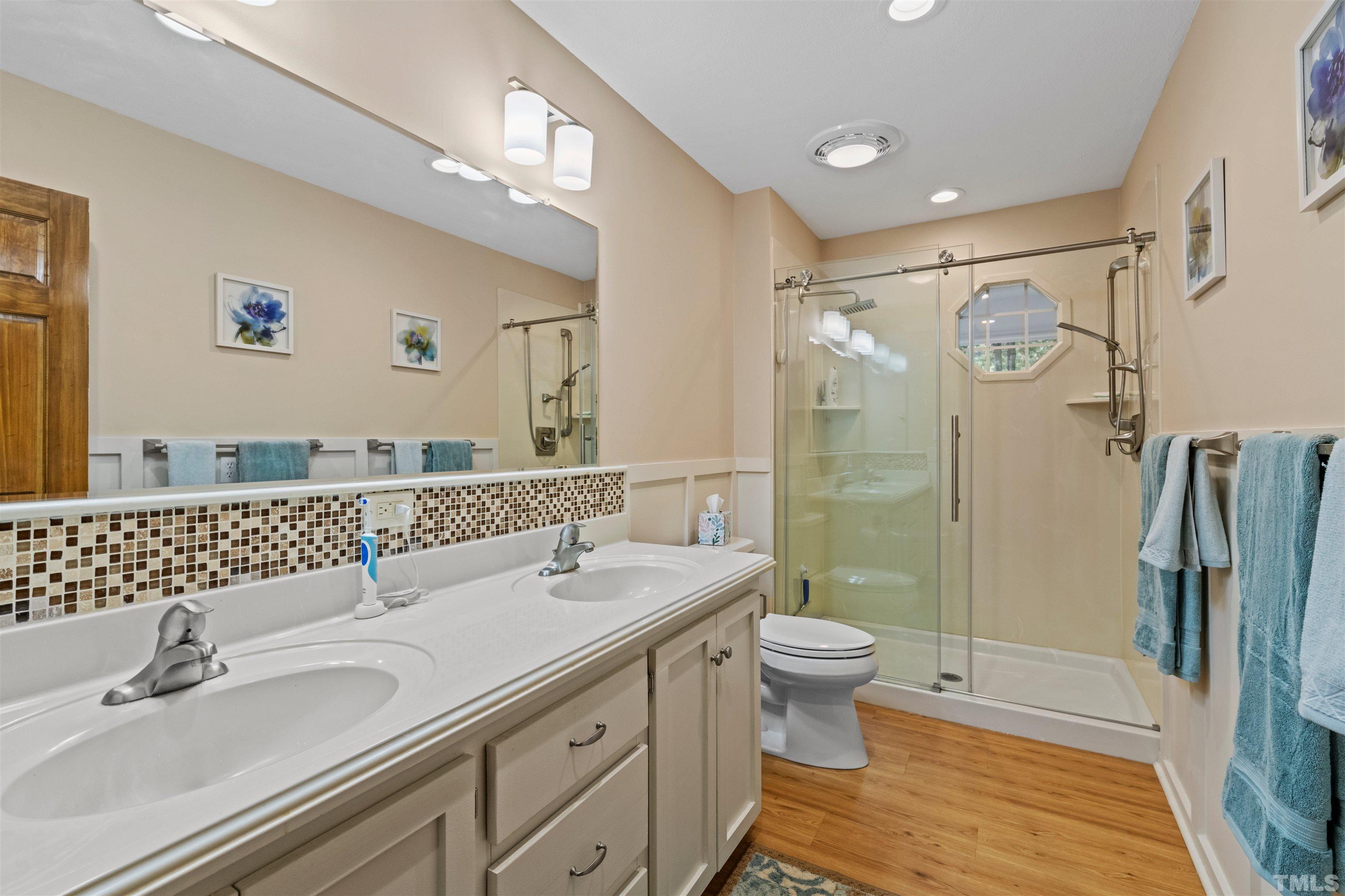 8417 Crowder Road Raleigh, NC 27603 - Photo 18 of 30 a bathroom with a double vanity sink mirror and toilet