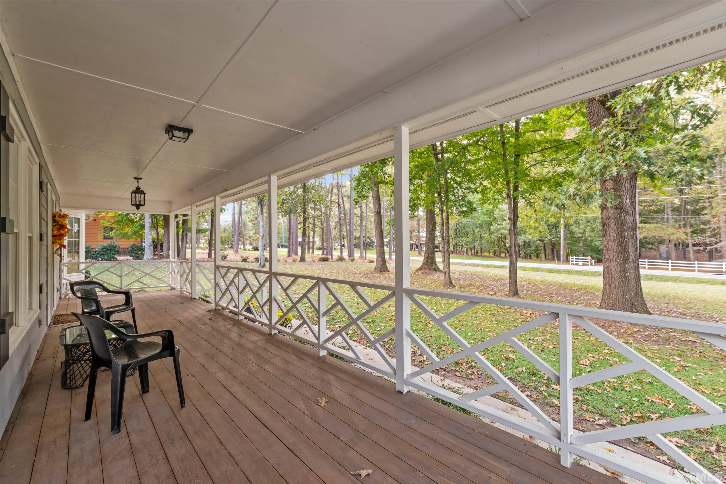 8417 Crowder Road Raleigh, NC 27603 - Photo 3 of 30 a view of a balcony with chairs and wooden floor