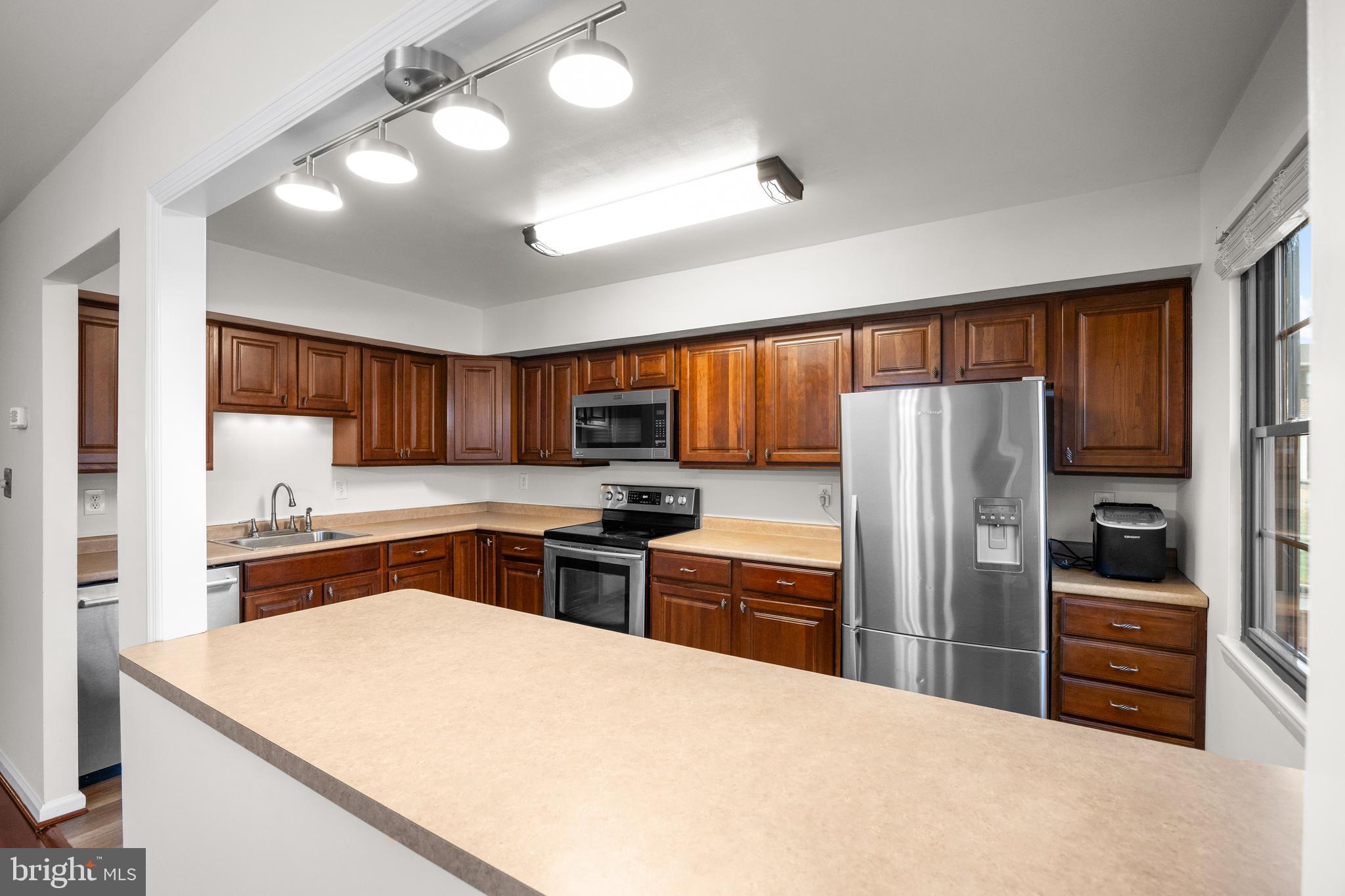 33 Badger Gate Court Baltimore, MD 21228 - Photo 17 of 39 a kitchen with stainless steel appliances granite countertop a refrigerator stove and sink