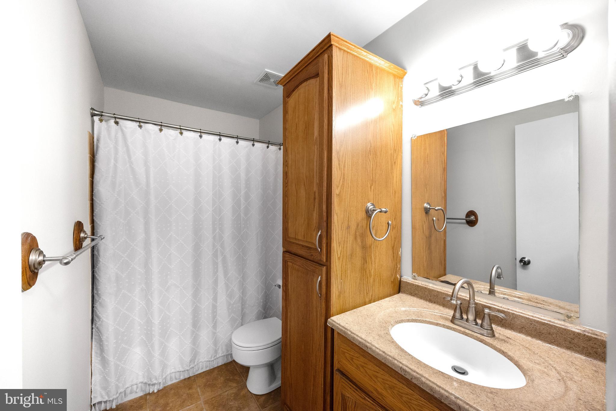 33 Badger Gate Court Baltimore, MD 21228 - Photo 31 of 39 a bathroom with a granite countertop sink toilet and shower