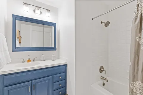 a bathroom with a sink vanity tub and shower