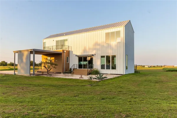 a living room with furniture floor to ceiling window and an outdoor view