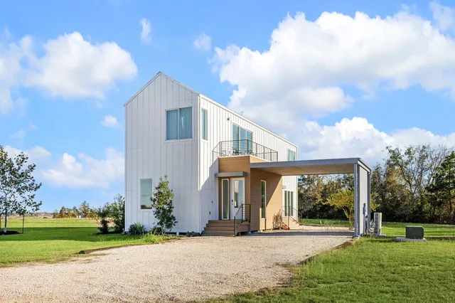 a front view of a house with a yard and potted plants