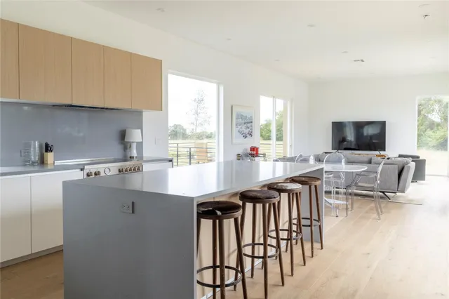 a kitchen with stainless steel appliances kitchen island granite countertop a table chairs sink and cabinets