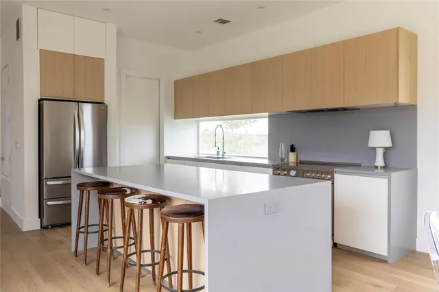 a kitchen with granite countertop a refrigerator and a stove top oven