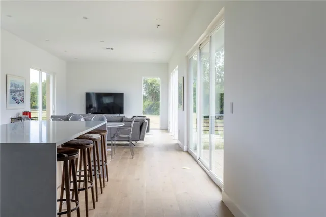 a living room with furniture a flat screen tv and a large window