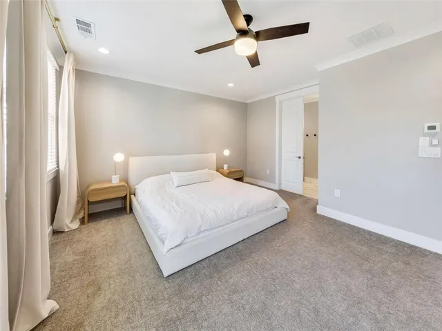 a spacious bedroom with a bed and a chandelier