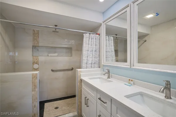 a bathroom with a shower sink and mirror