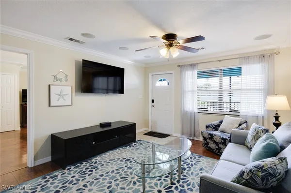 a kitchen with stainless steel appliances granite countertop a dining table chairs refrigerator and sink