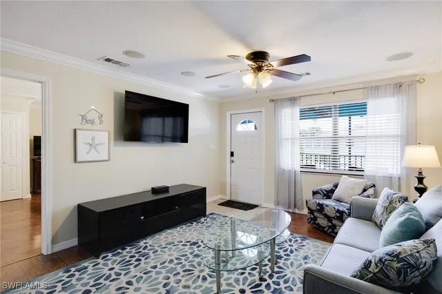 a kitchen with stainless steel appliances granite countertop a dining table chairs refrigerator and sink