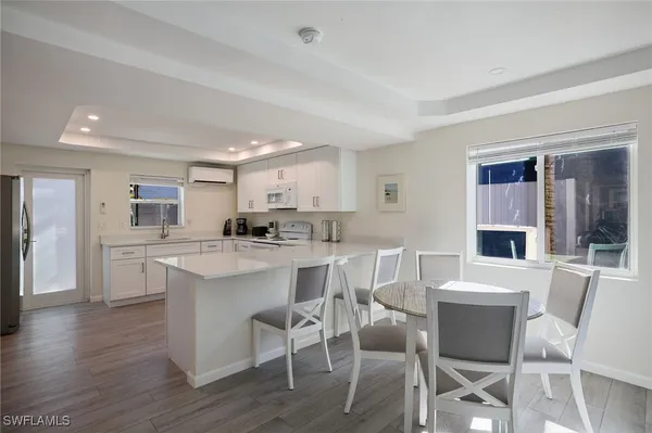a kitchen with a dining table chairs and refrigerator