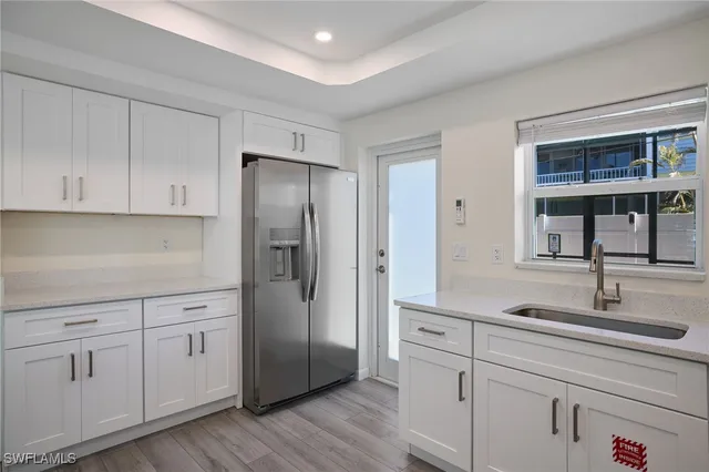 a kitchen with white cabinets and refrigerator